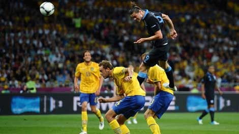 A. Carroll (áo sẫm) đánh đầu dũng mãnh, mở tỷ số cho đội Anh.