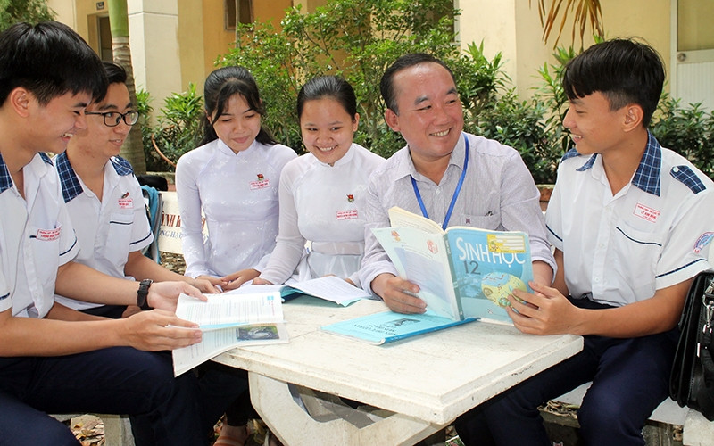 Thầy Hải (thứ hai từ phải sang) cùng các học sinh trao đổi phương pháp nghiên cứu khoa học.