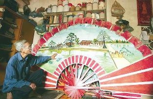 Nghệ nhân Dương Văn Mơ giới thiệu chiếc quạt gỗ.