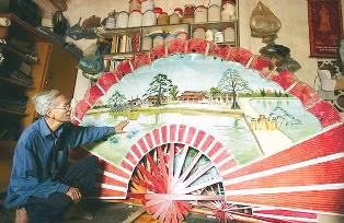 Nghệ nhân Dương Văn Mơ giới thiệu chiếc quạt gỗ.