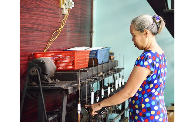 Bà Trương Thị Hoa kiểm tra sản phẩm dệt thủ công của gia đình.