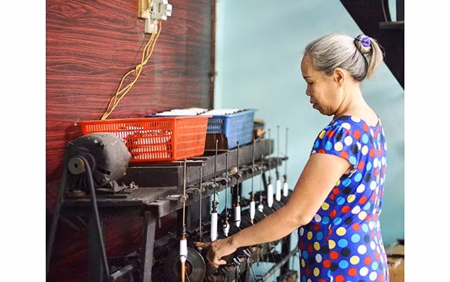 Bà Trương Thị Hoa kiểm tra sản phẩm dệt thủ công của gia đình.