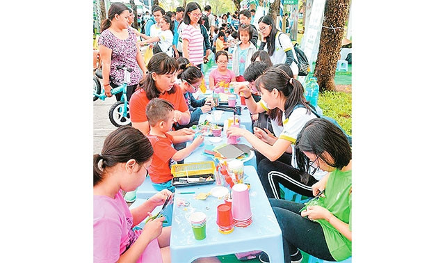 Hướng dẫn các bé tái chế ly nhựa tại Ngày Hội sống xanh.