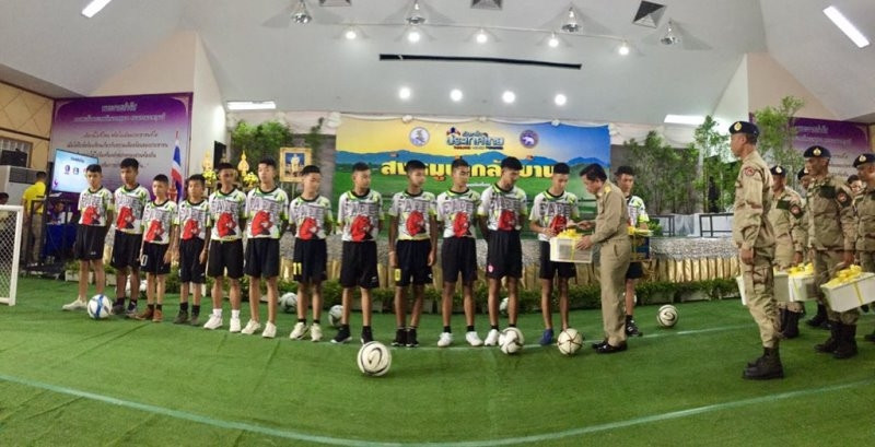 Cuộc họp báo kết thúc, các thành viên đội bóng Lợn Rừng trở về với gia đình và bạn bè. Mỗi em đều được nhận quà của Thủ tướng Thái-lan Prayut Chan-ocha. (Ảnh: Channel NewsAsia)