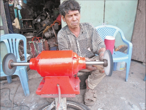 Anh Bảy cặm cụi đánh bóng lư đồng để "tận hưởng không khí đón Tết và kiếm tiền".