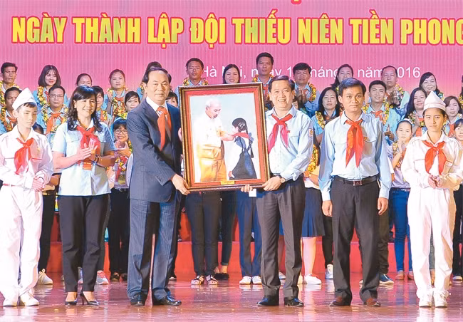 Chủ tịch nước Trần Đại Quang trao bức ảnh "Chủ tịch Hồ Chí Minh đeo khăn quàng đỏ cho thiếu nhi" tặng Hội đồng Đội Trung ương. Ảnh: LINH PHAN
