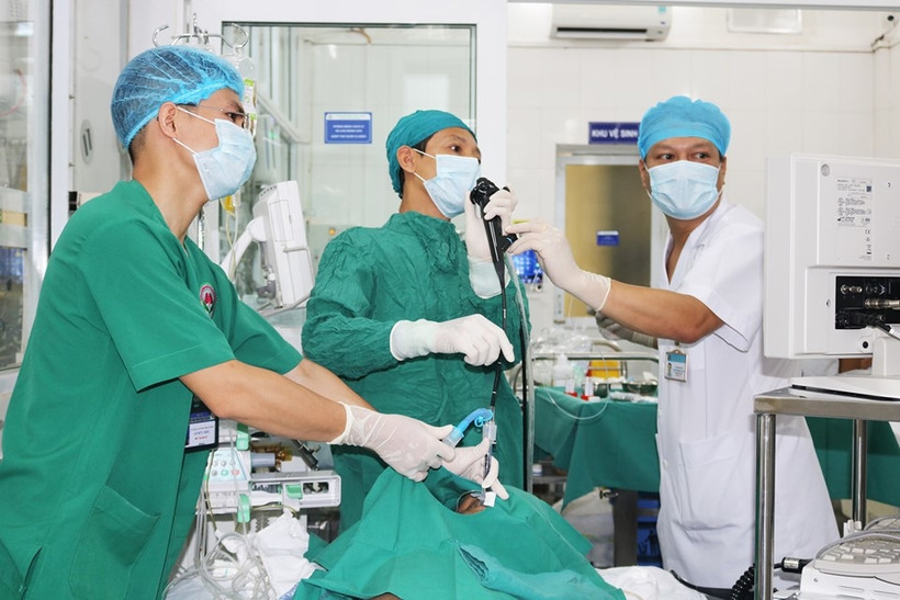 Các bác sĩ can thiệp lấy cầu răng giả cho cụ ông. 