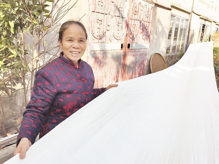 Nghệ nhân Phan Thị Thuận bên chiếc mền tơ do tằm tự dệt.