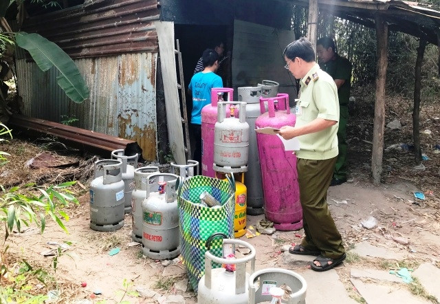 Lực lượng chức năng lập biên bản thu giữ các loại bình gas tại hiện trường.