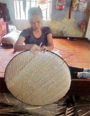 Bên chiếc giường gỗ mộc, chị Liên đang hằng ngày đan nong.