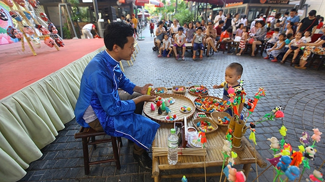 Miệt mài với nghề cổ, nghệ nhân trẻ Văn Hậu mang lại niềm thích thú cho các em nhỏ.