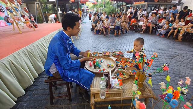 Miệt mài với nghề cổ, nghệ nhân trẻ Văn Hậu mang lại niềm thích thú cho các em nhỏ.