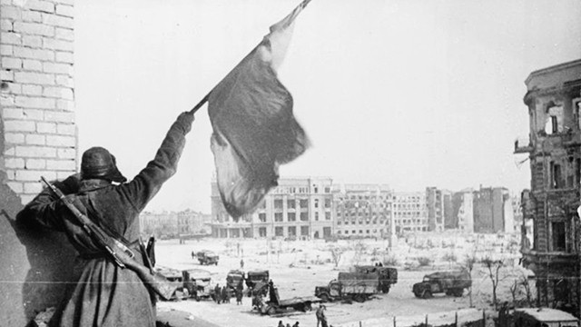 Một chiến sĩ Hồng quân giương cao ngọn cờ chiến thắng trong trận Stalingrad. Ảnh tư liệu