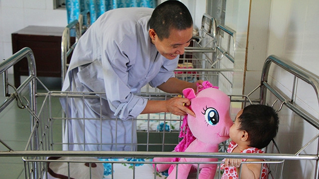 Một bé gần tuổi được các sư hay đến vui đùa, các em xem các sư như mẹ mình.