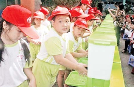 Cần quan tâm giữ vệ sinh cho trẻ trong ăn uống và tẩy giun định kỳ. Trong ảnh: Học sinh Trường mầm non 9, quận 3, TP Hồ Chí Minh thực hiện rửa tay bằng xà-phòng.