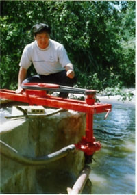 Thầy giáo Trần Đình Huân bên
chiếc máy bơm của mình.