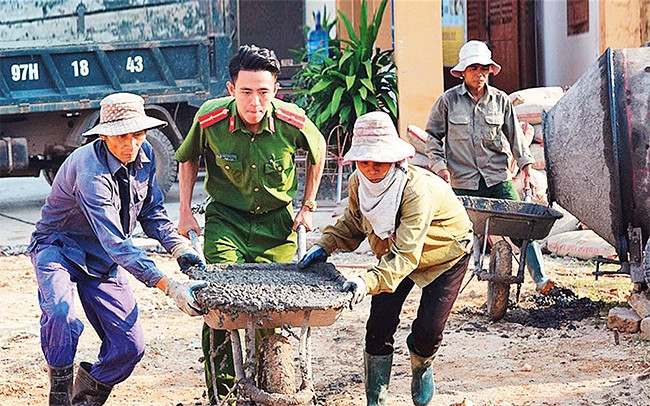 Cán bộ, chiến sĩ Công an thị xã Đông Triều (tỉnh Quảng Ninh) đóng góp ngày công cùng nhân dân thôn An Trại, xã Việt Dân. Ảnh: VĂN ANH
