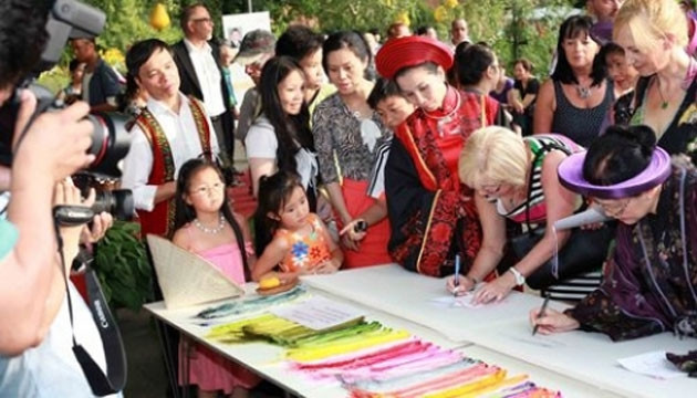 Ðông đảo khách nước ngoài và Việt kiều ký tên vào mẫu tranh thêu trong lễ hội XQ Việt Nam tổ chức tại TP Pô-xđam (CHLB Ðức).