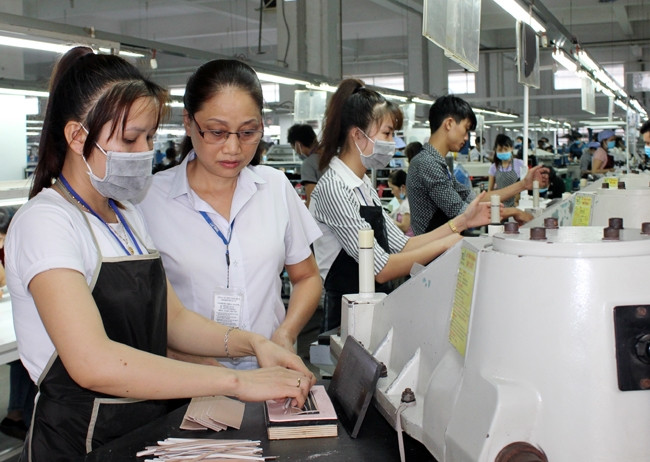 Đảng viên Nguyễn Thị Hương (thứ hai từ trái sang) hướng dẫn công nhân trong dây chuyền sản xuất.