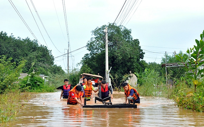 Lực lượng chức năng sơ tán các hộ dân và vật dụng bị ảnh hưởng do nước lũ tại phường Tân Đồng (TP Đồng Xoài, tỉnh Bình Phước) đến nơi an toàn. Ảnh: NHẤT SƠN