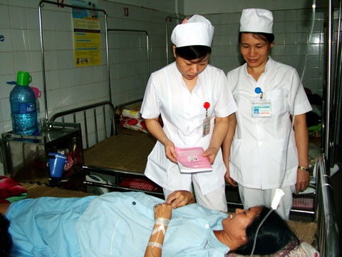 Bác sĩ Lê Thị Nga và Nguyễn Thị Hoa (Bệnh viện Phụ sản Thanh Hóa) hướng dẫn cách sử dụng sổ TDSKBMTE cho chị Nguyễn Thị Minh.