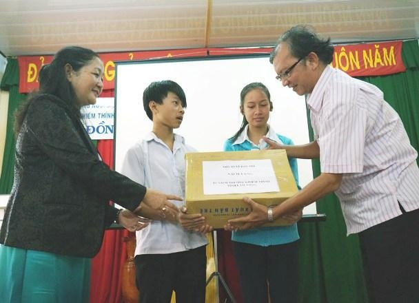 Chủ tịch HĐQT NXB Trẻ (bên phải) trao tặng sách cho Trường khiếm thính Lâm Đồng.