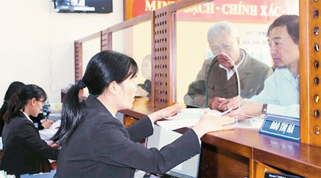 Hướng dẫn người dân làm thủ tục cấp giấy chứng nhận quyền sử dụng đất tại bộ phận "một cửa" UBND huyện Gia Lâm. Ảnh: NAM GIANG