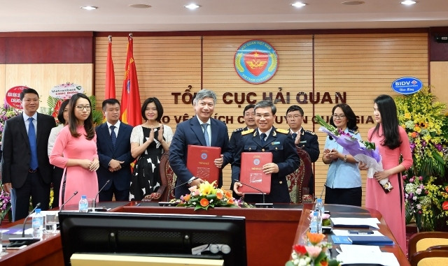 Ông Nguyễn Danh Lương, Phó Tổng Giám đốc Vietcombank (hàng đầu, bên phải) và ông Nguyễn Dương Thái, Phó Tổng Cục trưởng Hải quan đại diện hai bên ký kết thỏa thuận triển khai dịch vụ nộp thuế hải quan