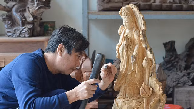 Nghệ nhân Nguyễn Văn Truyền hoàn thành tác phẩm. Ảnh: LAN ANH