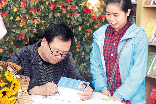 Nhà văn Nguyễn Nhật Ánh ký tặng sách cho độc giả. Ảnh: Việt Khôi 