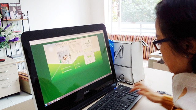 Người dân giờ đã làm quen với các tiện ích từ giao dịch điện tử, điều đó gây áp lực không nhỏ đối với doanh thu từ dịch vụ truyền thống của các ngân hàng. Ảnh: DOÃN TRƯỜNG