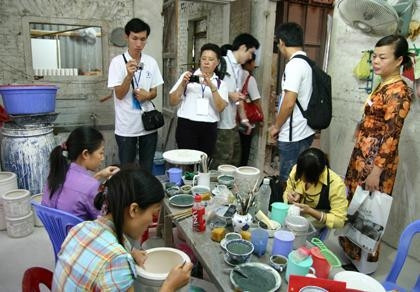 Khách du lịch tham quan một xưởng làm gốm tại làng nghề Bát Tràng.