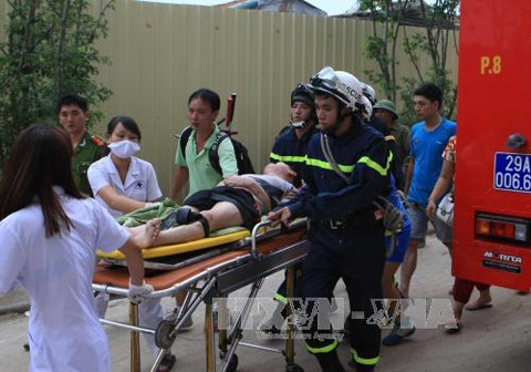 Giải cứu người bị nạn trong vụ cháy ở tòa nhà HH4A, Khu đô thị Linh Đàm (Hà Nội). Ảnh TTXVN