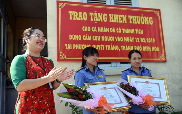 Trưởng Ban Thi đua khen thưởng tỉnh Đồng Nai Vy Vũ Hồng Thảo trao bằng khen cho hai nhân viên gác chắn dũng cảm cứu người.
