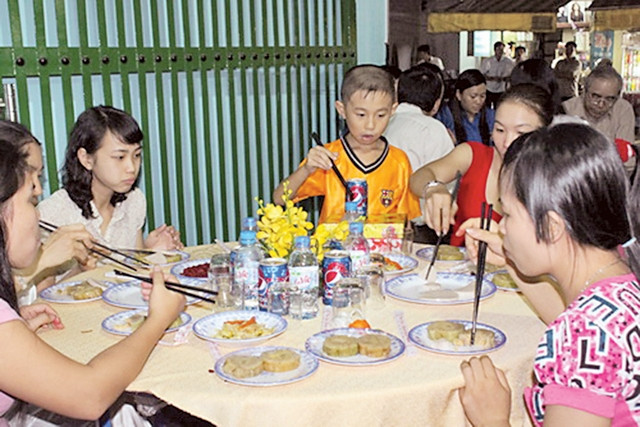 Các gia đình công nhân ăn Tết tại xóm trọ 143 Trần Thanh Mai, Q. Bình Tân, TP Hồ Chí Minh. Ảnh: TRUNG CHÁNH