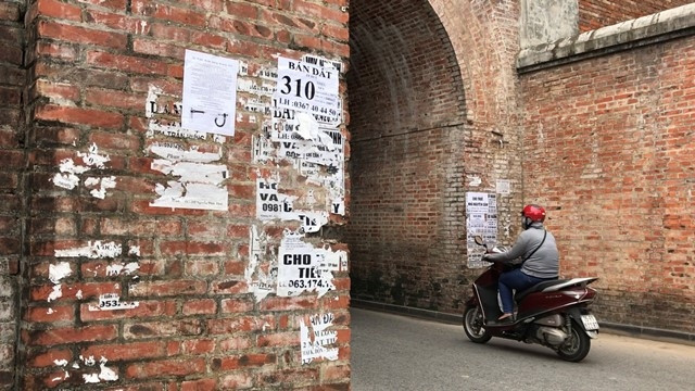 Giấy có nội dung quảng cáo, rao vặt được dán đầy hai bên cửa Hữu kinh thành Huế.