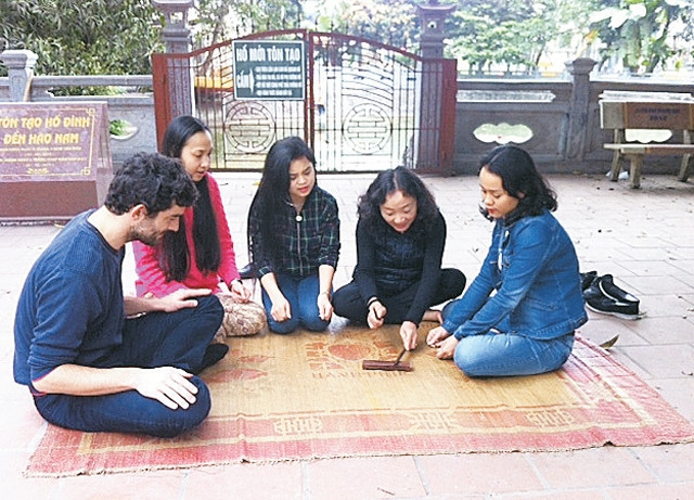 Nghệ nhân Phùng Thị Hồng (thứ hai từ phải sang) hướng dẫn các học trò tại đình Hào Nam (Hà Nội) cách gõ phách trong nghệ thuật ca trù.