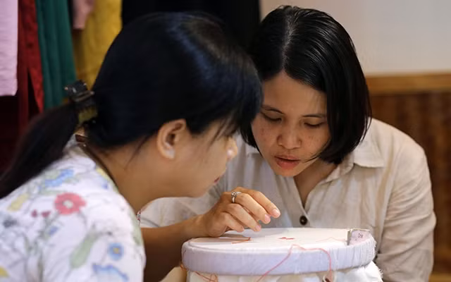  Mai Lan, chủ tiệm thêu Tú Thị (bên phải) hướng dẫn học viên.