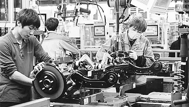 Công nhân làm việc tại nhà máy sản xuất phụ tùng ô-tô ở thành phố Asan, Hàn Quốc.