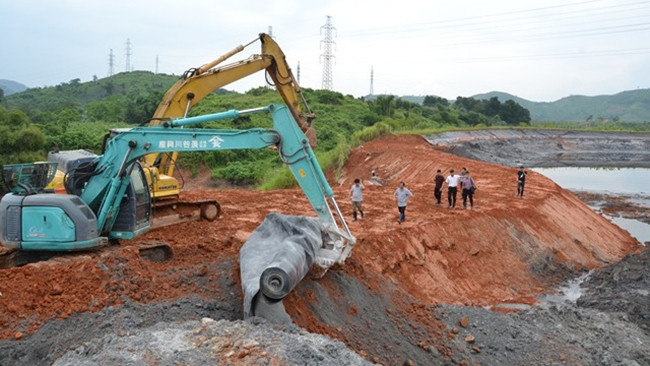 Các lực lượng cứu hộ tích cực thi công đê quây hàn khẩu bờ bao bị vỡ của hồ chứa nước thải của Nhà máy DAP Lào Cai, sáng ngày 9-9- 2018.