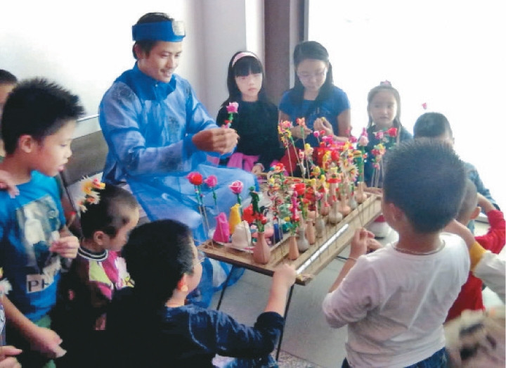 Nghệ nhân Nguyễn Văn Thành, làng Xuân La hướng dẫn trẻ em ở Times City nặn tò he.