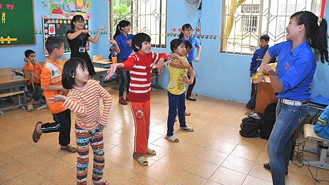 Niềm vui của các em nhỏ tại Trung tâm Phục hồi Chức năng Việt - Hàn khi đoàn tình nguyện tới thăm. Trong ảnh: Tình nguyện viên Đoàn TNCS Hồ Chí Minh hướng dẫn các em múa dân vũ.