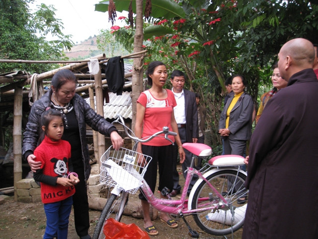 Các nhà hảo tâm thăm, tặng xe đạp cho gia đình chị Điêu Thị Vĩnh.
