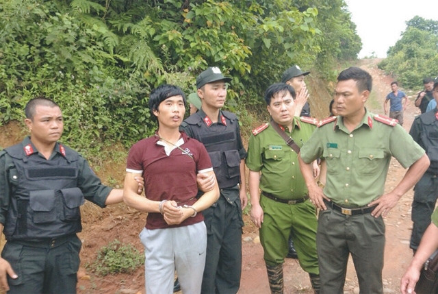 Lực lượng công an dẫn giải đối tượng Tẩn Láo Lở thực nghiệm lại hiện trường vụ sát hại bốn người trong gia đình anh Tẩn Ông Nải. Ảnh | XUÂN MAI