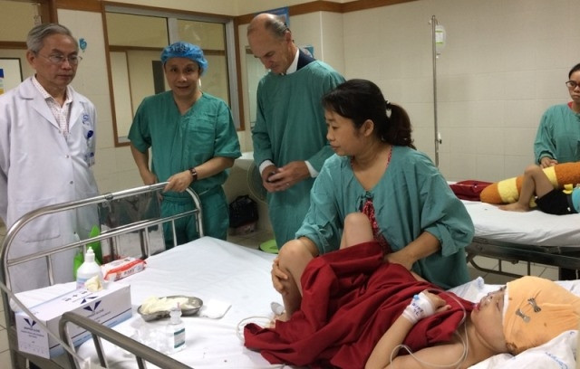 GS Phạm Như Hiệp, Giám đốc Bệnh viện T.Ư Huế và GS McKay McKinnnon thăm cháu P. (Ảnh: Bệnh viện cung cấp)