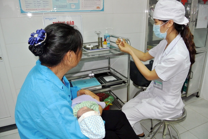 Nhân viên y tế Bệnh viện Đa khoa Bắc Giang kiểm tra, đối chiếu vắc-xin viêm gan B trước khi tiêm cho trẻ.