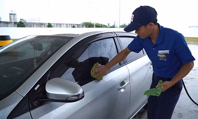 Việc nhân viên lau xe sau khi bơm xăng tại trạm xăng của Công ty Idemitsui Q8 (IQ8) mang lại sự hài lòng cho khách hàng. Ảnh: HOÀNG HIỆP