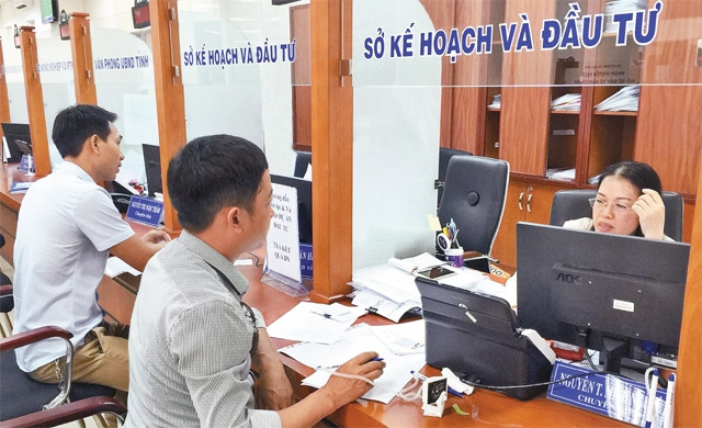 Cán bộ bộ phận một cửa Sở Kế hoạch và Đầu tư tỉnh Bà Rịa - Vũng Tàu hướng dẫn người dân tra cứu tiến độ giải quyết hồ sơ.