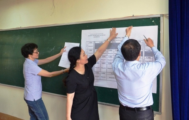 Cán bộ coi thi của Trường ĐH Luật Hà Nội niêm yết sơ đồ phòng thi và danh sách thí sinh tại điểm thi Trường CĐSP Lào Cai. (Ảnh: QUỐC HỒNG)