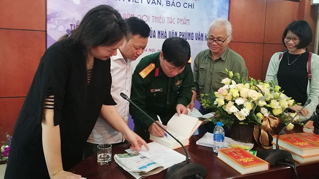 Trung tá, nhà văn Phùng Văn Khai ký tặng độc giả tại buổi ra mắt tiểu thuyết “Ngô Vương” sáng 4-4 tại Trường đại học Văn hóa, Hà Nội.